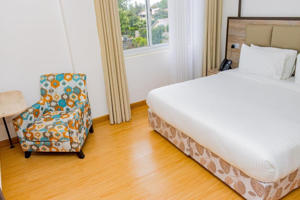 a hotel room with a bed and a chair at Landmark Hotel Nanyuki in Nanyuki