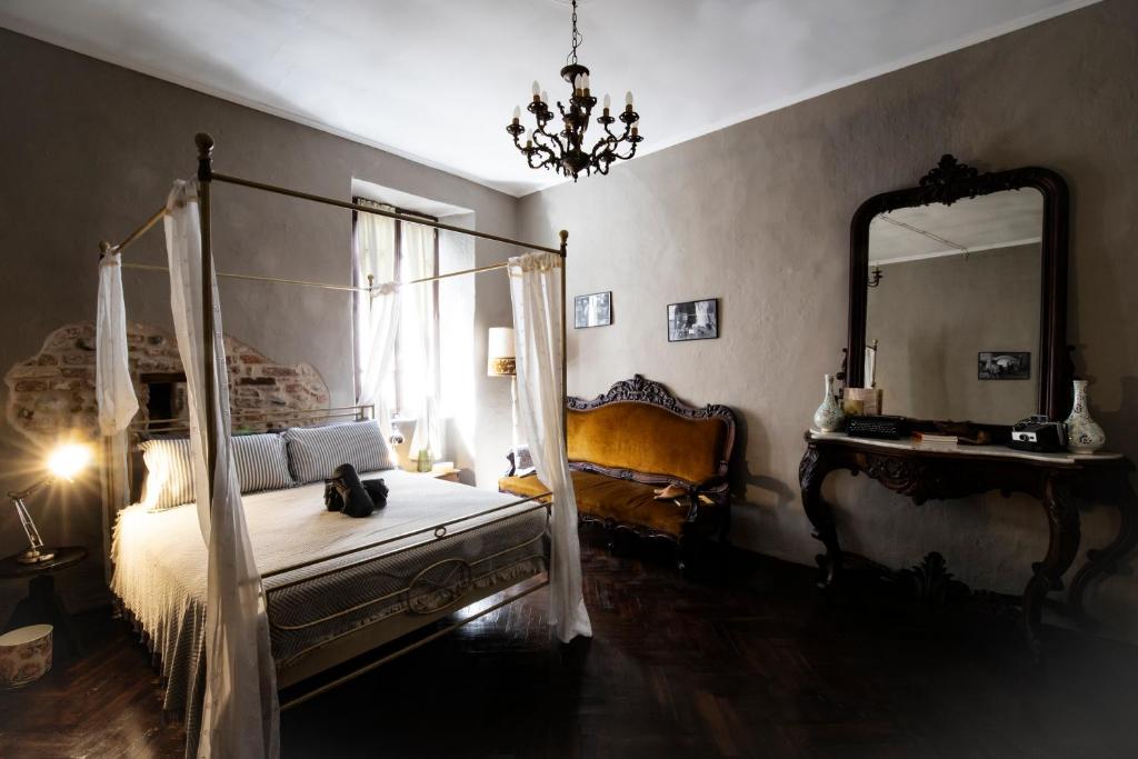 a bedroom with a canopy bed and a large mirror at Il Ciabattino di Ceva in Ceva