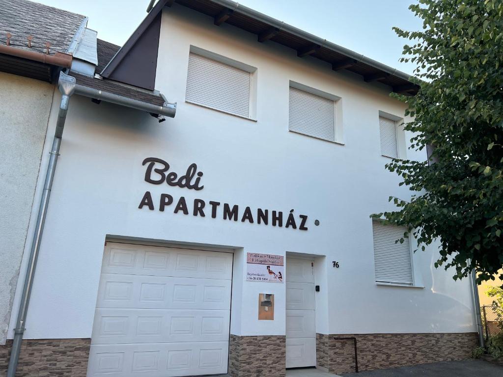 a white building with a sign that reads bell a participantamine at Bedi Apartmanház in Nagykanizsa