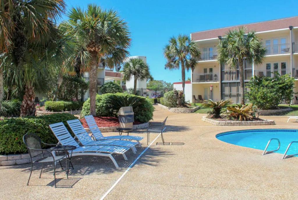 a group of chairs and a pool in front of a building at Seaside Treasure in Biloxi
