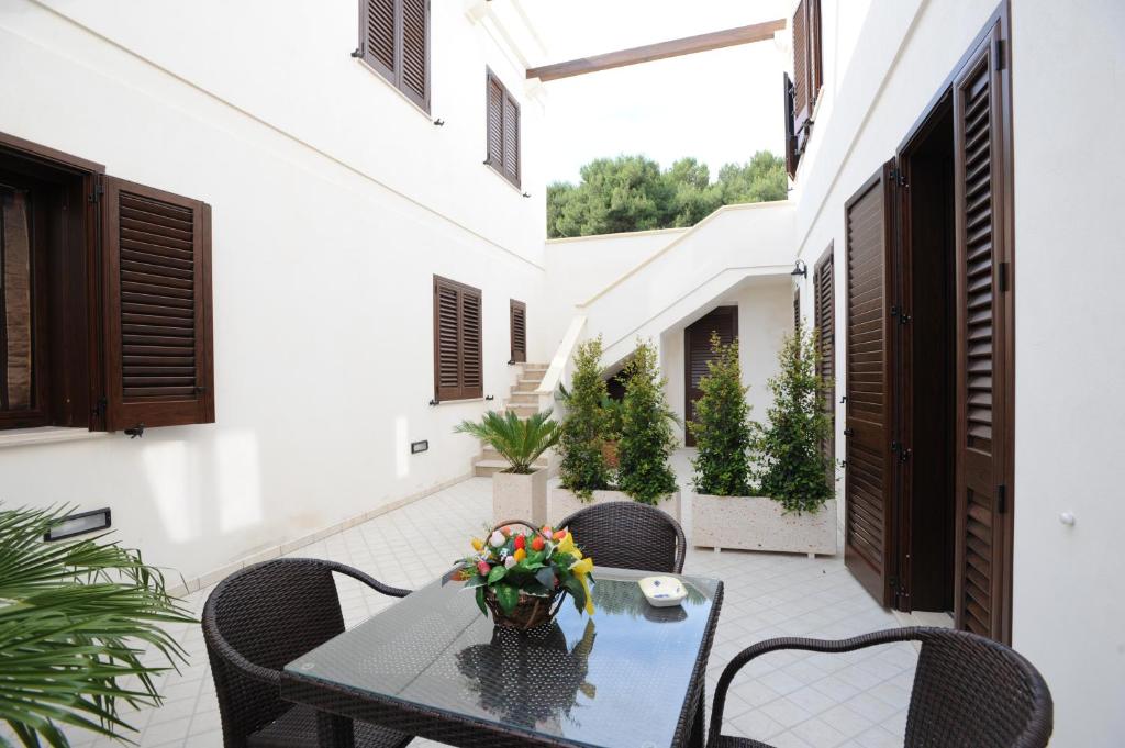 een patio met een tafel met bloemen erop bij Carmelina 3 in Marina di Pescoluse