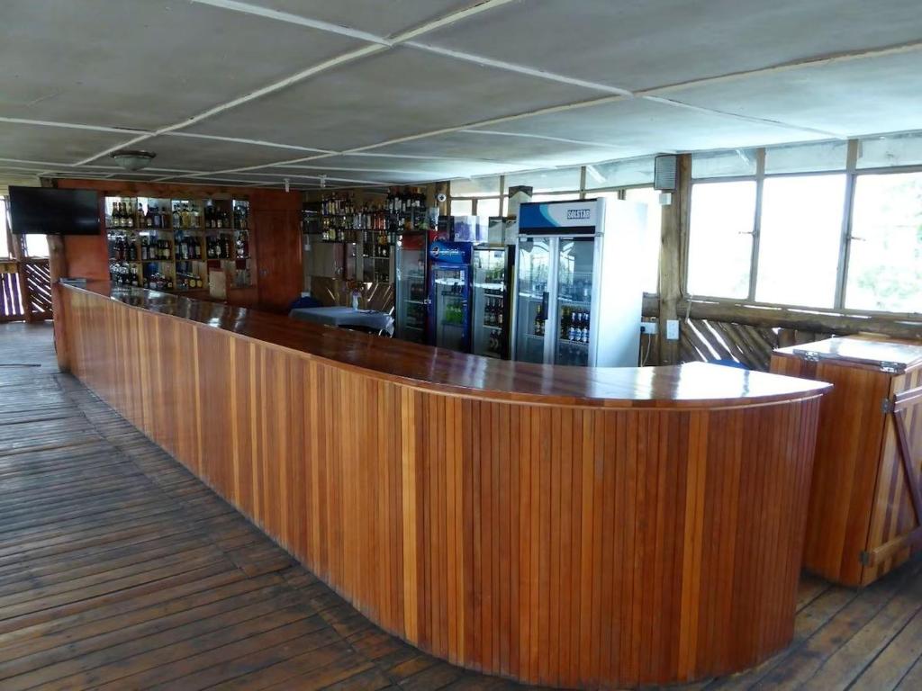 a wooden bar in a room with a counter at Delhi Gardens Hotel in Fort Portal
