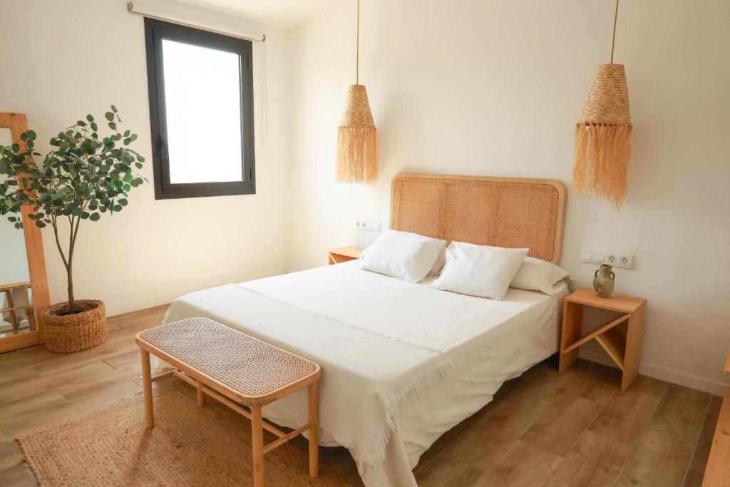 a bedroom with a white bed and a window at Apartaments Bellreguard in Papiol