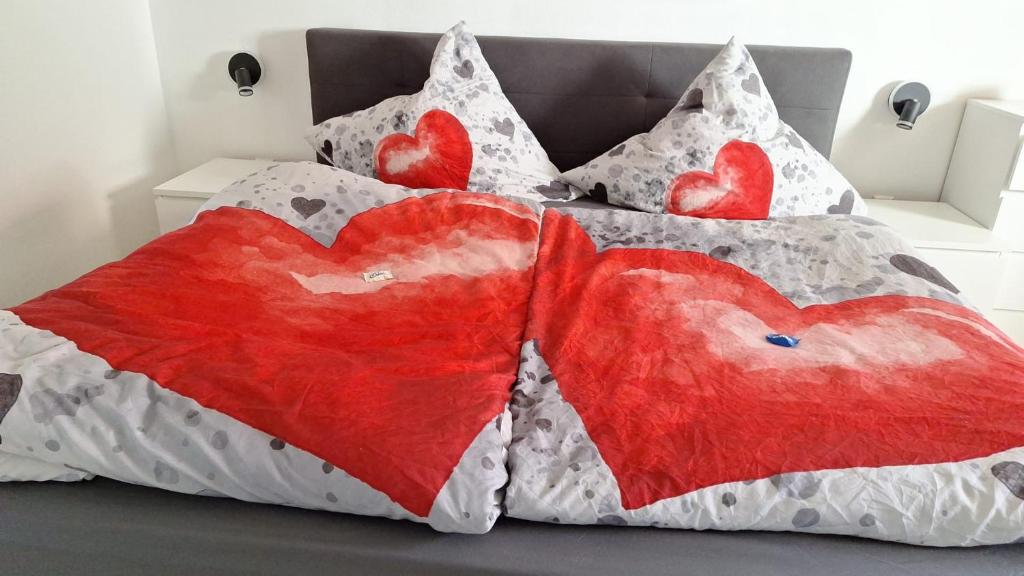 a bed with two hearts cushions on it at Am Fuße des Zoller in Bisingen