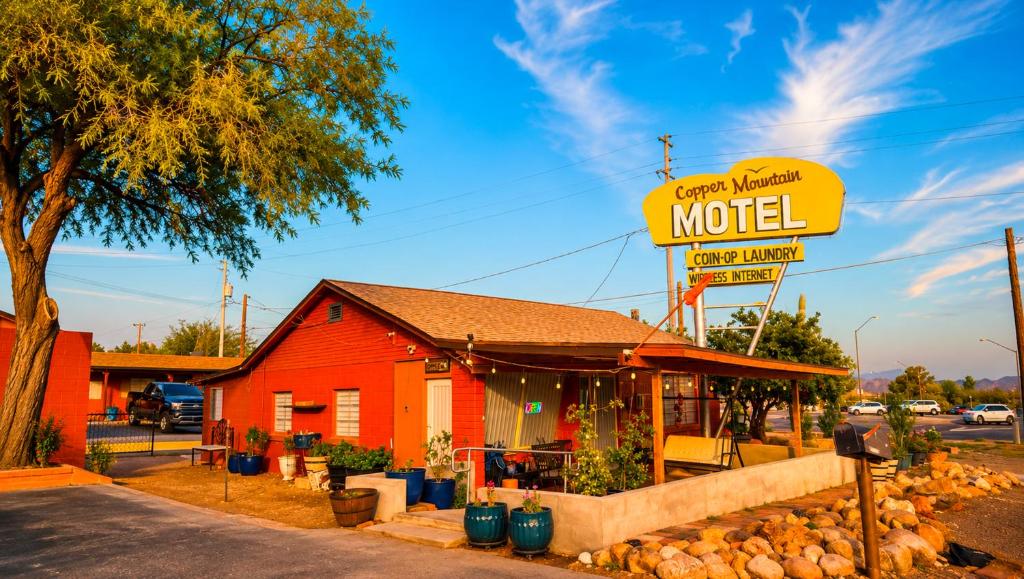 a motel sign in front of a red building at Copper Mountain Motel in Superior