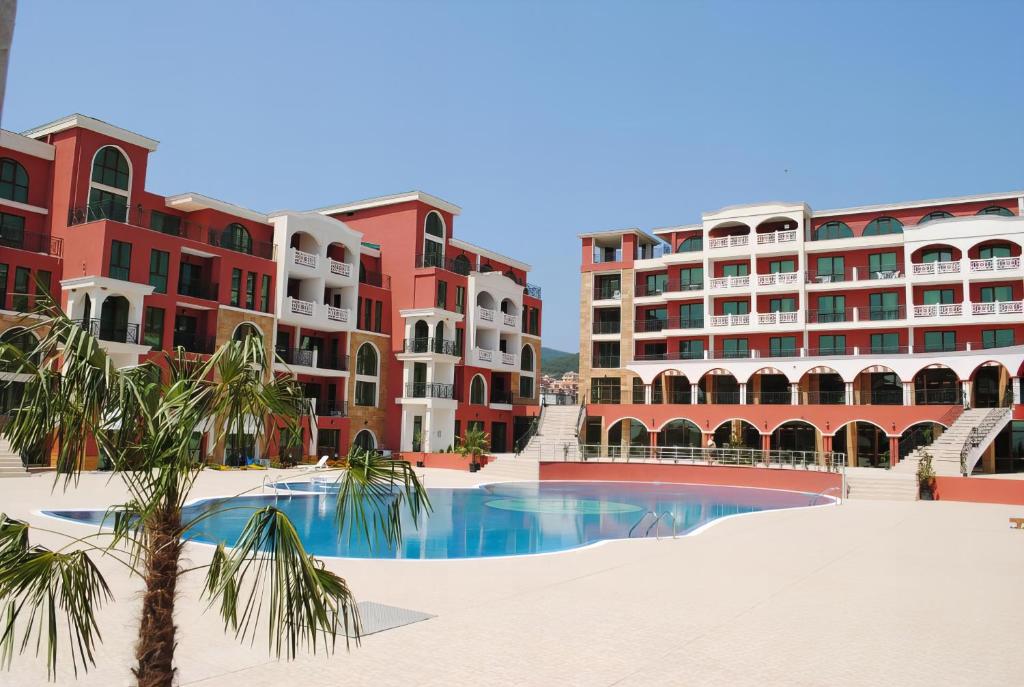 a view of a resort with a palm tree and buildings at Saint George Palace Hotel All-inclusive in Sveti Vlas