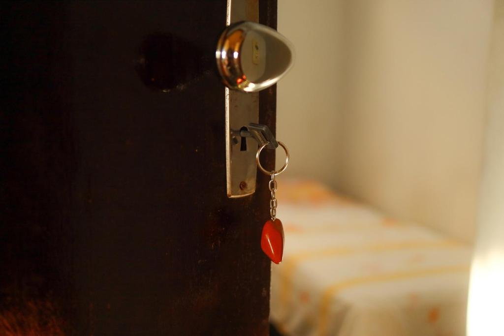 a door with a key in a room with a bed at Pousada 3 Bruxas Casa de Hóspedes in São Thomé das Letras