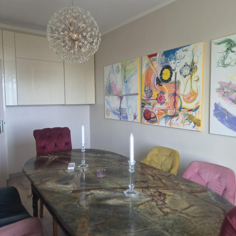 a dining room with a table and chairs and a chandelier at Apartament Stephen in Constanţa