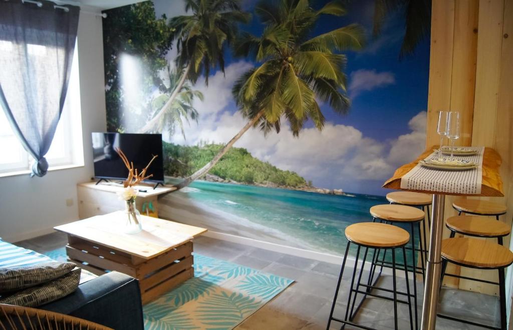 a room with a mural of a beach with a palm tree at La Playa - 5 couchages climatisé in Romans-sur-Isère