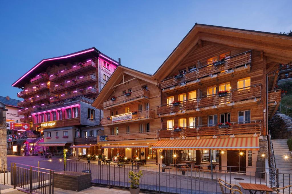 a large wooden building with balconies on a street at Eiger Guesthouse in Mürren