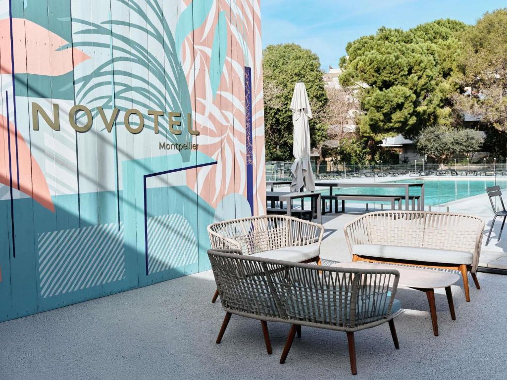 a group of chairs and tables next to a pool at Novotel Montpellier in Montpellier