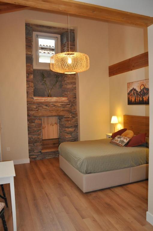 a bedroom with a bed and a stone wall at Estudio con Rincón de Cortesía Pusantenea in Berástegui