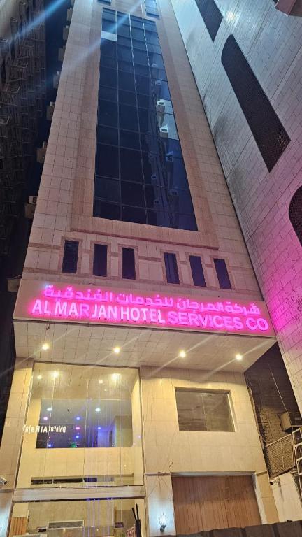 a building with a pink sign on the front of it at فندق المرجان للخدمات الفندقية in Jarwal