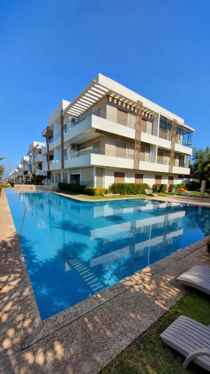 a building with a swimming pool in front of it at Casa bay2 in Sidi Rahal
