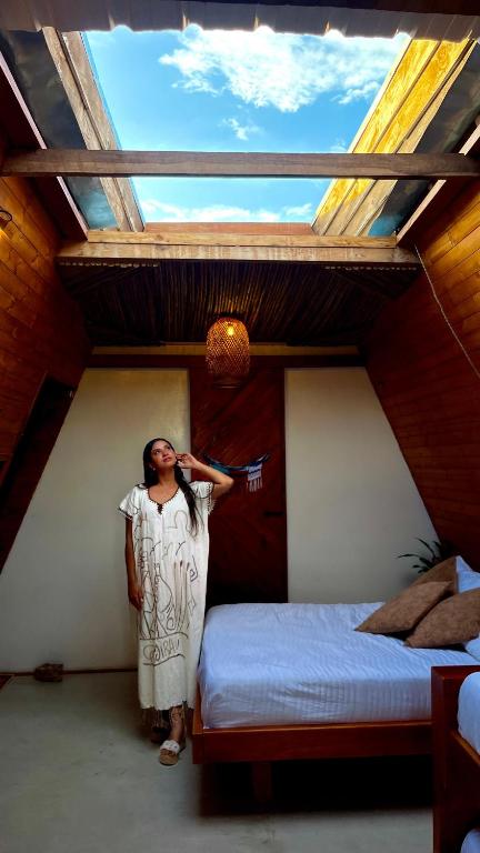 a woman standing in front of a bedroom with a window at Vbelasofia in Cabo de la Vela