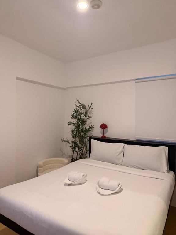 a white bed with two hats on top of it at serenity suites tagaytay in Tagaytay