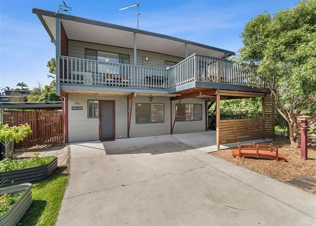 a large house with a balcony and a driveway at Mindil Arch Walk to 3 Beaches & River in Tomakin