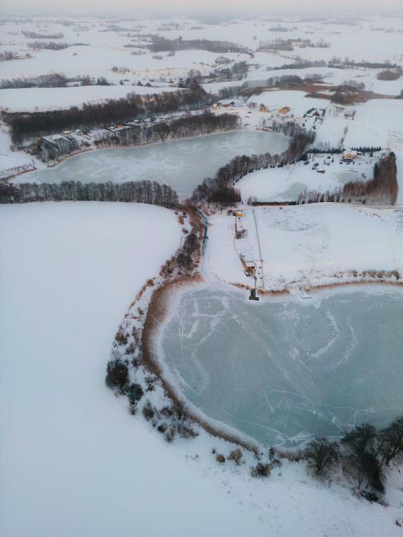 an aerial view of a frozen lake in the snow at Osada Sielankowo - Kopiec in Żałe