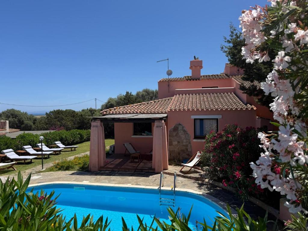 a villa with a swimming pool and a house at Villa LUMIè Stintino in Stintino