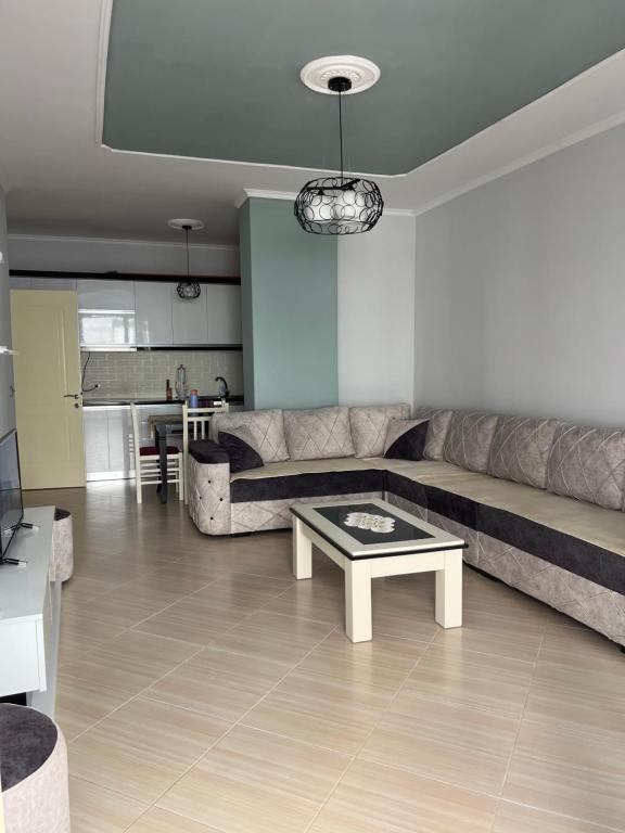 a living room with a couch and a coffee table at Elsuarha Apartment in Pogradec