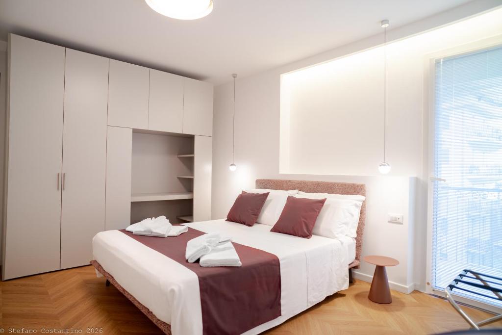 a white bedroom with a large bed and a window at Appartamento Bianca in Letojanni