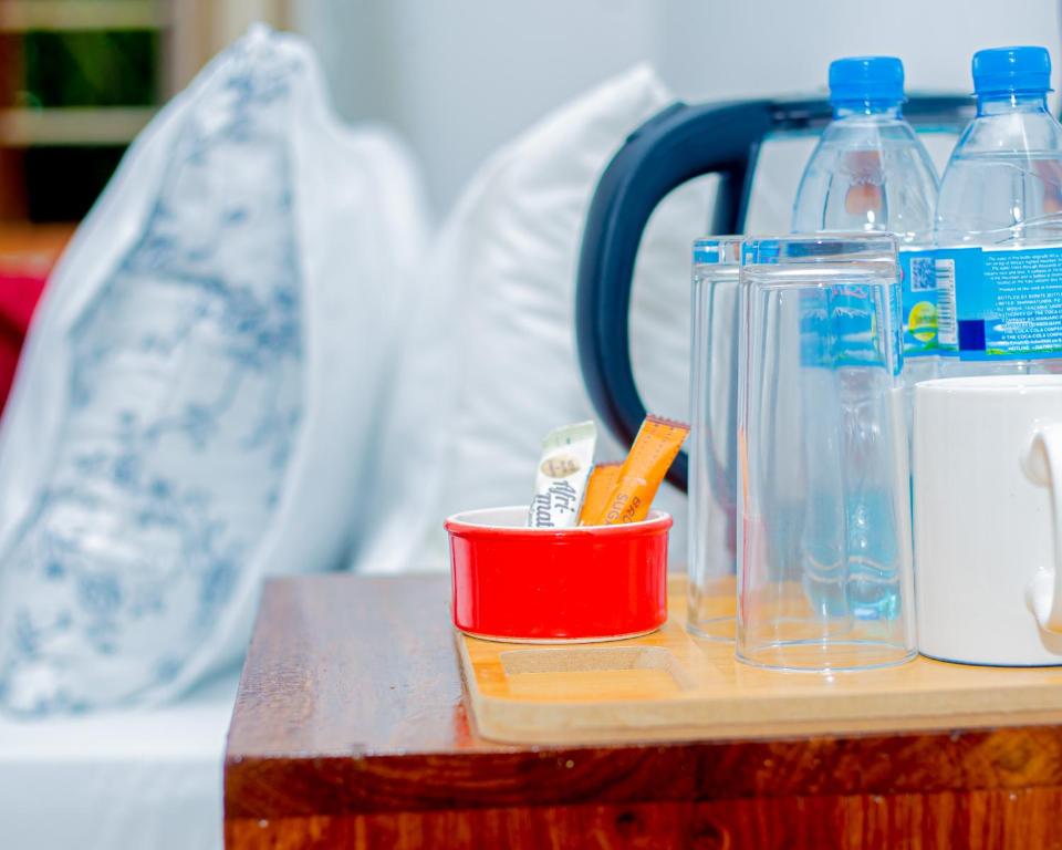 a table with a red cup and bottles on it at Furavia Hotel stay in Moshi