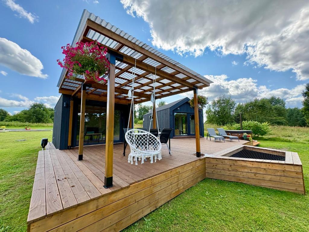 a deck with a table and chairs on a house at Rātes Krasti - Rasa - holiday house with sauna and lakeview in Lejasciems