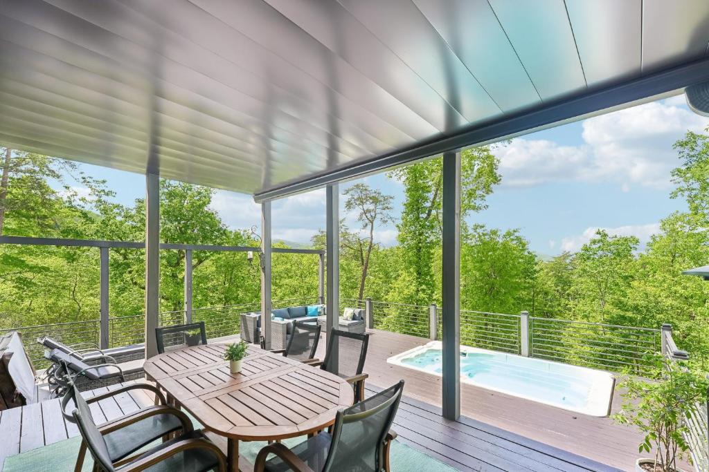 a deck with a table and chairs and a pool at Casa del Sueño - Big Canoe, GA - Take a Dip in the Private Swim Spa, Rack Up a Game of Pool, and Stay Active in the In-Home Fitn in Afton
