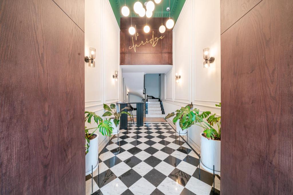 a hallway with potted plants and a checkered floor at VIVASTAY Casablanca -Corniche Le claridge Emerauld with gym and rooftop in Casablanca