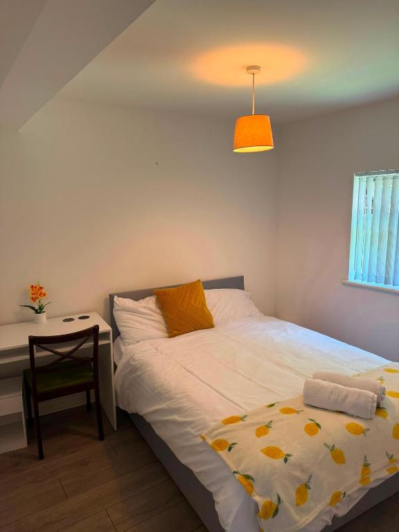 a bedroom with a bed and a table and a lamp at Heathrow One Bed Family Flat in South Ruislip Station