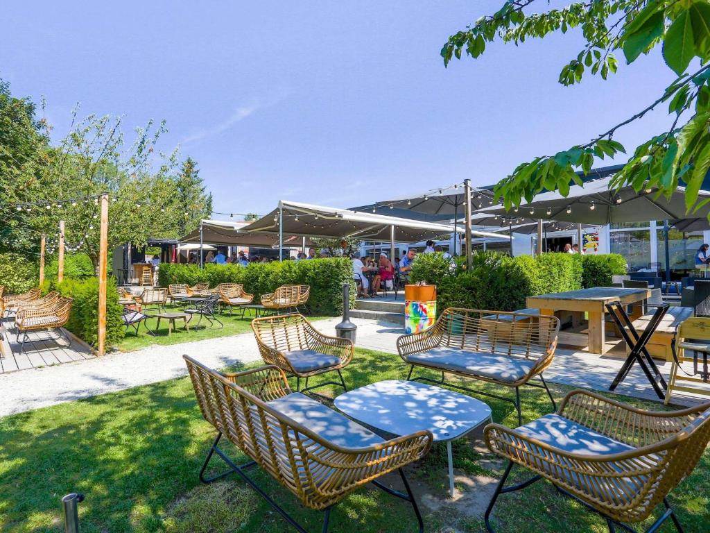 a group of chairs and tables in a yard at Mercure Lille Marcq en Baroeul in Marcq-en-Baroeul