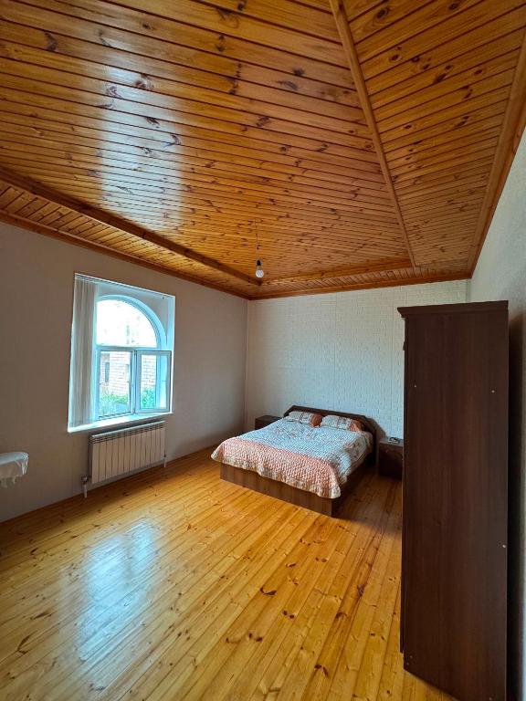 a bedroom with a bed and a wooden ceiling at Palm Garden House Lankaran in Lankaran