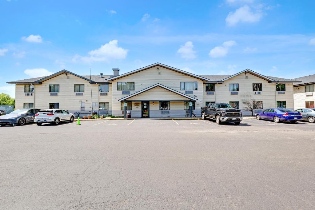 a large building with cars parked in a parking lot at Coldwater Inn & Suites near I 69 in Coldwater