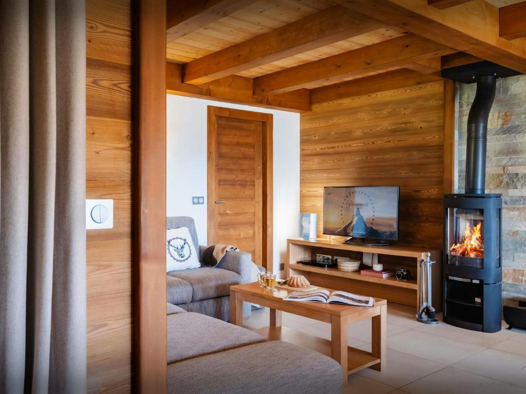 a living room with a fireplace and a couch at Pralor Le Peille - OVO Network in Manigod
