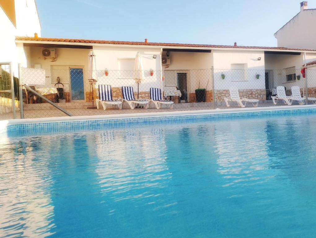 a swimming pool with chairs and a house at AR El ENCÍN TR-CC-00592 in Valdencin