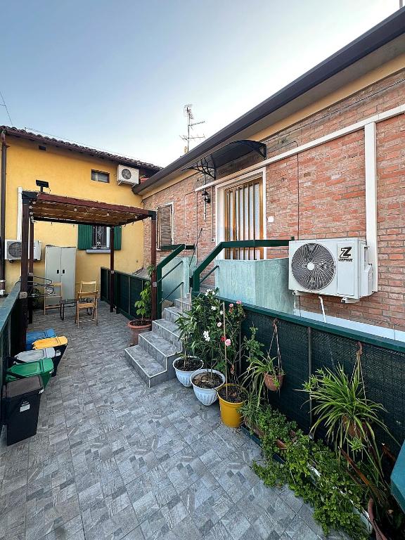 a patio with potted plants and a heater on a building at Eagle Apartment in Massa Lombarda