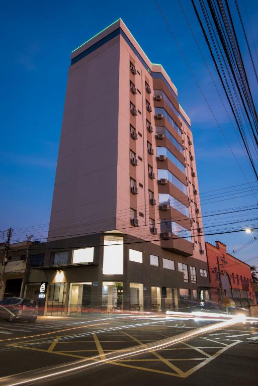 a tall building on the corner of a street at EKO HOTEL in Presidente Prudente