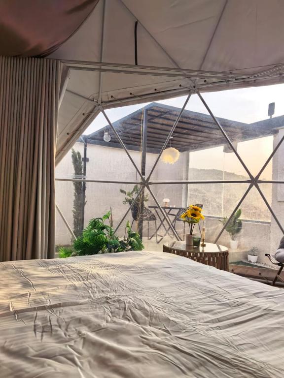 a large bed in a room with a large window at شاليهات سكوْن in Al Baha