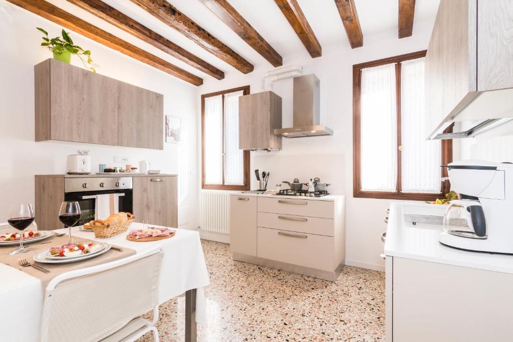 a kitchen with white cabinets and a table with food on it at Cà Boldo Terrace 2.0 in Venice