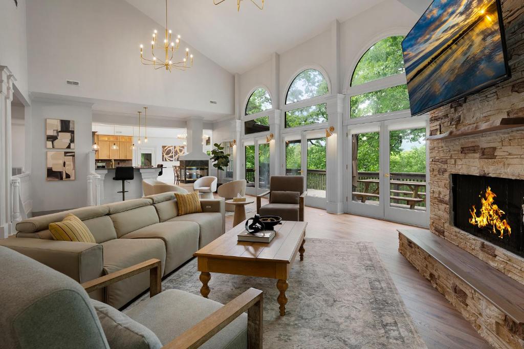 a living room with a couch and a fireplace at Modern Marble - Jasper, GA - Take in Sweeping Mountain Views, Soak in the Hot Tub, Stay Active in the Home Gym, and Mix Drinks a in Jasper