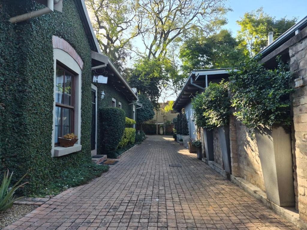 a cobblestone alley between two buildings with plants at Ambiance Guesthouse in Pretoria