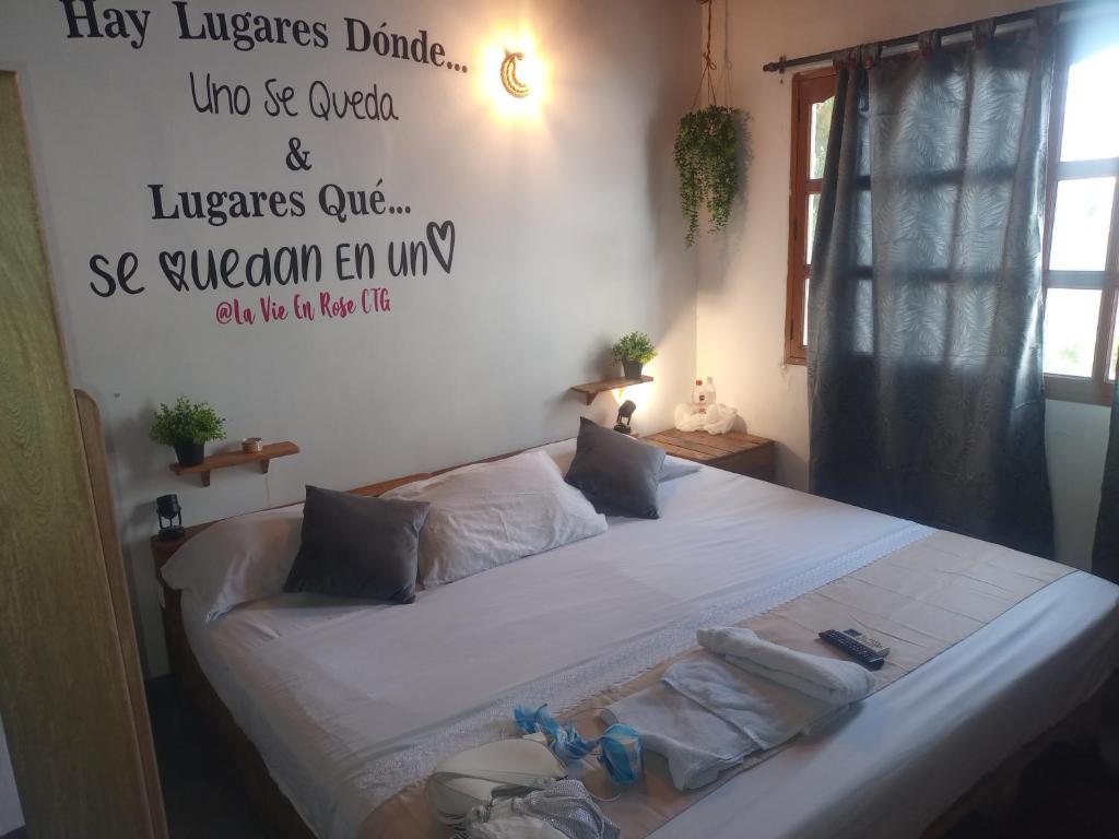 a bedroom with a bed with a sign on the wall at CONFORT Room AIRE AC - Desayuno - Tv - Baño Compartido - Excelente Ubicación Muelle Cruceros - Exquisita Atención y Buen Ambiente in Cartagena de Indias