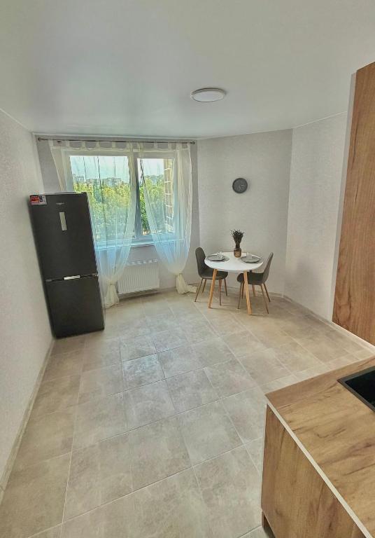 a kitchen with a table and a table and chairs at НОВИЙ ЖК ОДЕСЬКІ ТРАДИЦІЇ НА ГЛУШКО!є підземний паркінг! in Odesa