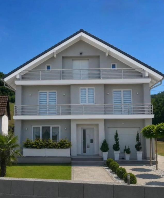 a large white house with a balcony at Luksuzna kuca sa bazenom 