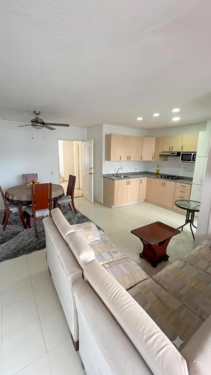 a living room with a white couch and a table at Tu refugio ideal cerca al mar in Playa Bello Horizonte