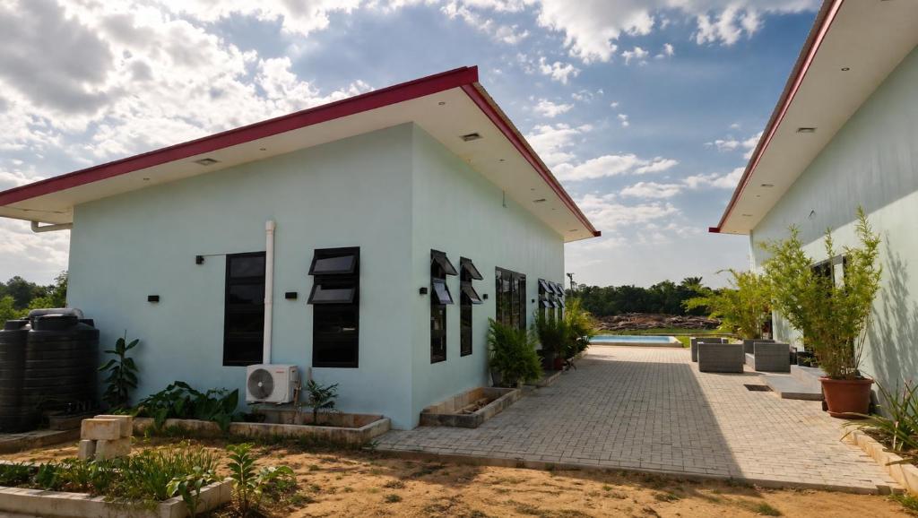 a white building with a red roof at Guesthouse AngaLampoe in Lelydorp