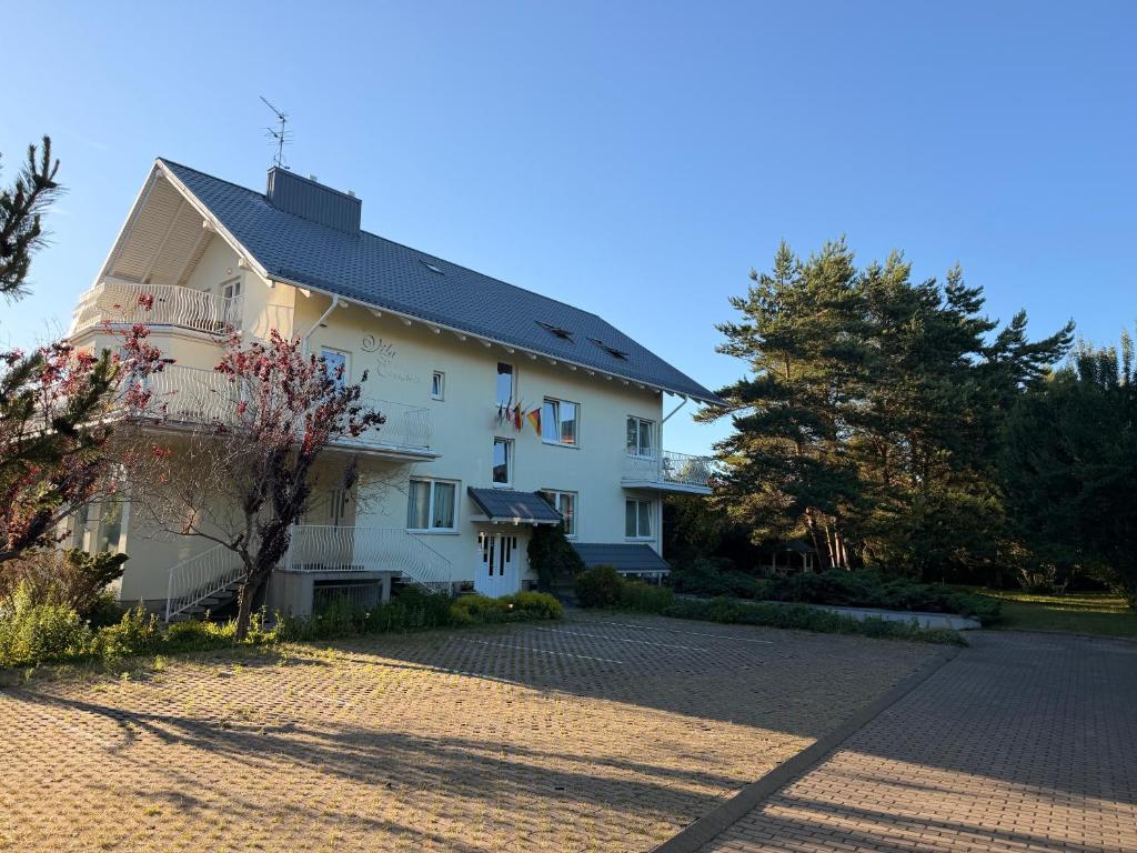 a large white building with a driveway at Villa Apartments in Palanga