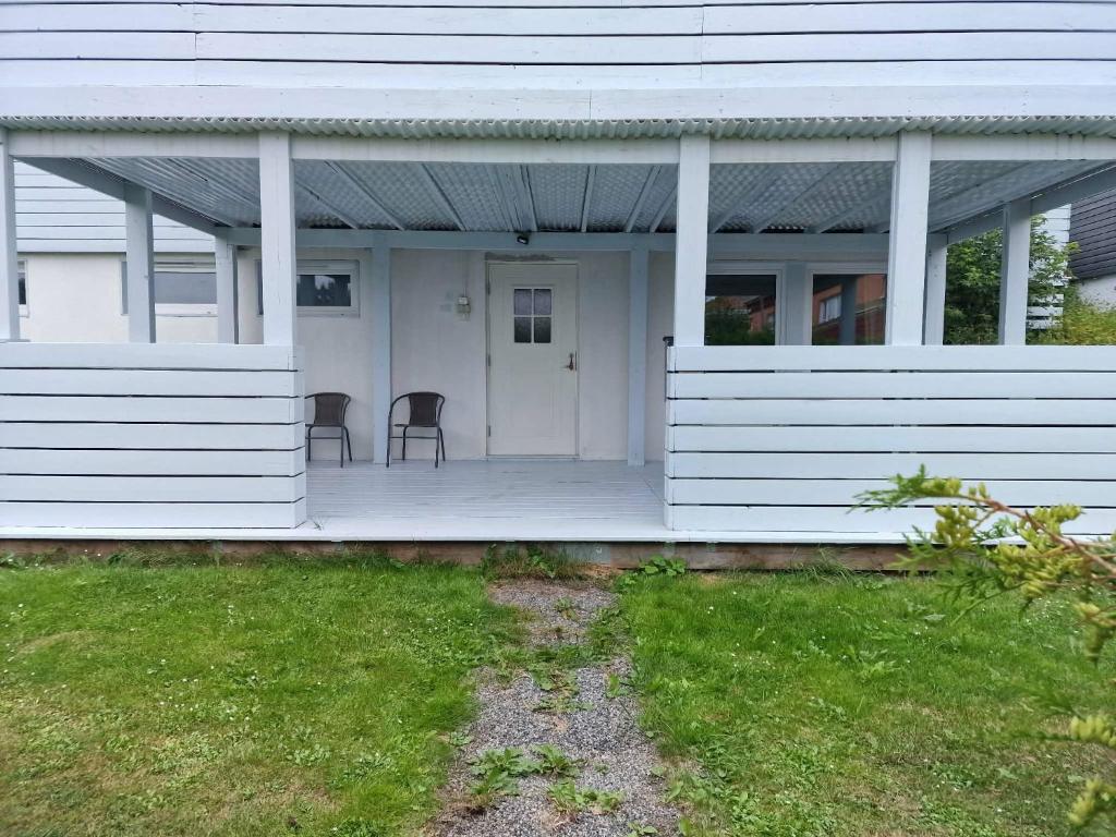 a white house with two chairs on a porch at Rimbo Hem in Rimbo