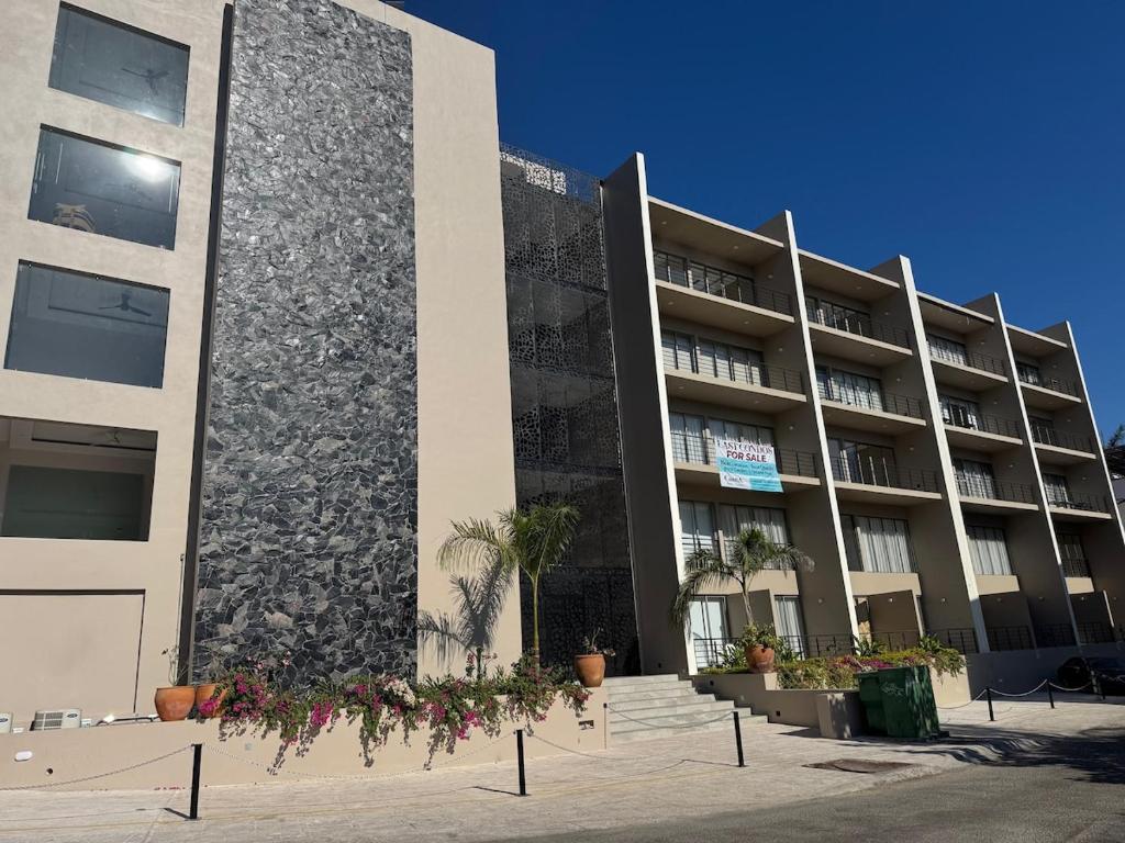 a large building with flowers in front of it at Santa Cruz Condo in Santa Cruz Huatulco