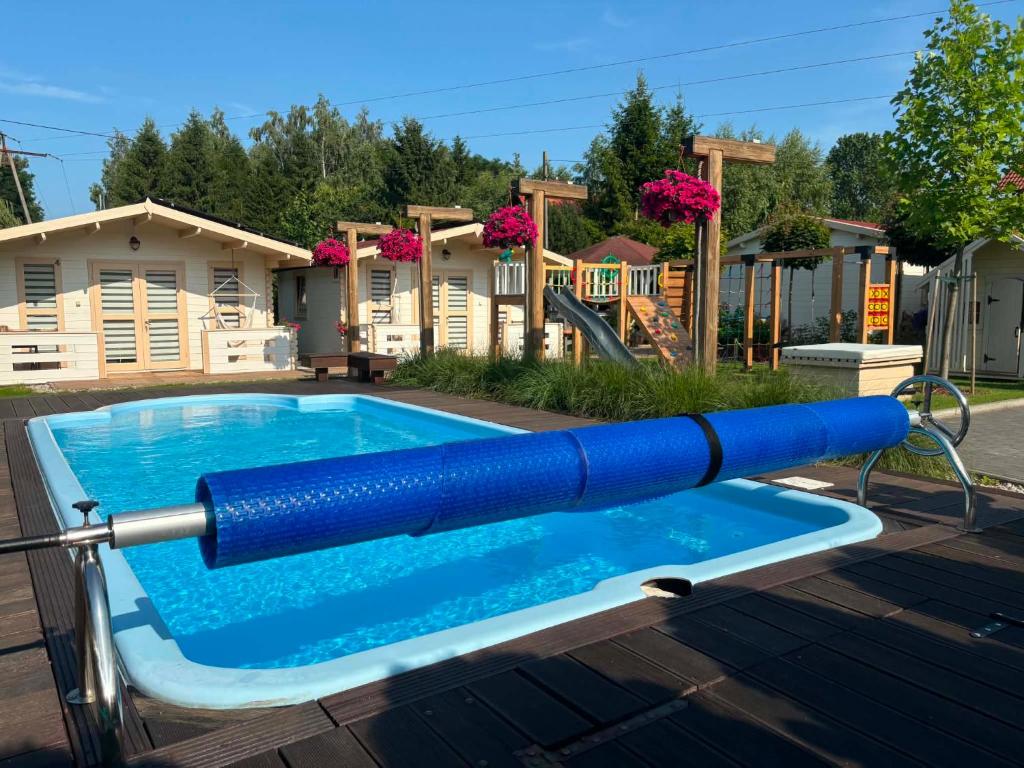 a pool with a blue water slide on a playground at Domki u Oli in Stegna